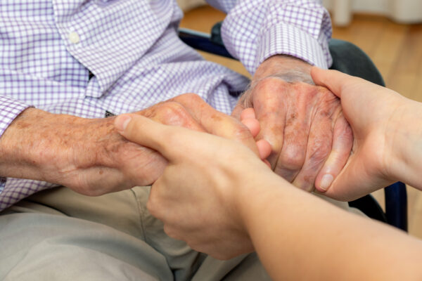 elderly person holding someones hands