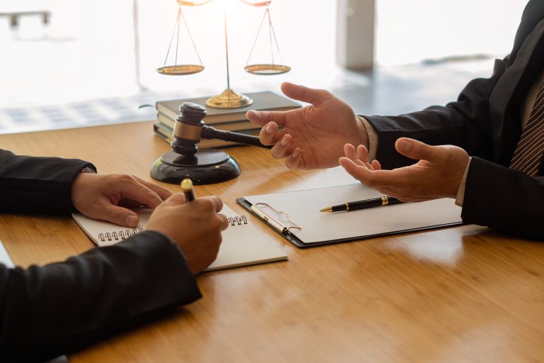 Businessman and lawyer discussing contract documents sitting at a table Legal ideas advice agreements with a partner attorney or lawyer discussing contractual agreements