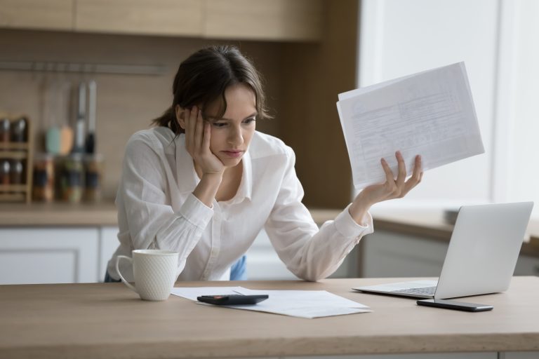 Worried woman feels shocked due to heap of unpaid bills