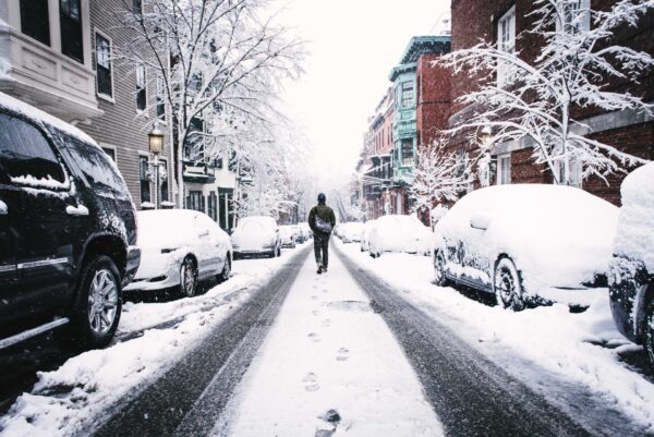 man walking down snowy street