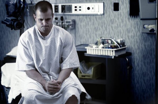 lifestyle photo of a young caucasian man as he waits in a hospital examination room