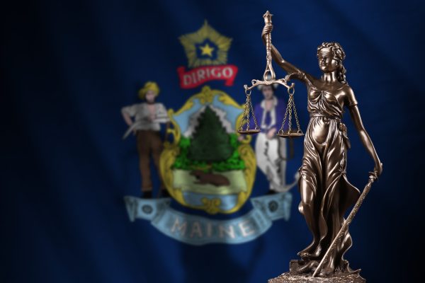 Maine,Us,State,Flag,With,Statue,Of,Lady,Justice,And